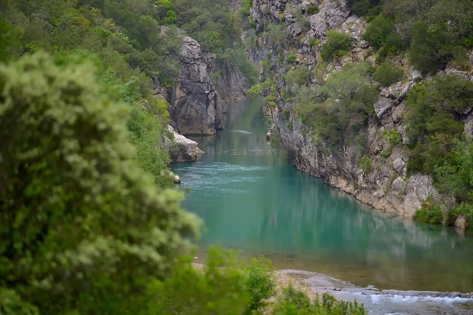 A turquoise river running through a steep limestone gorge
